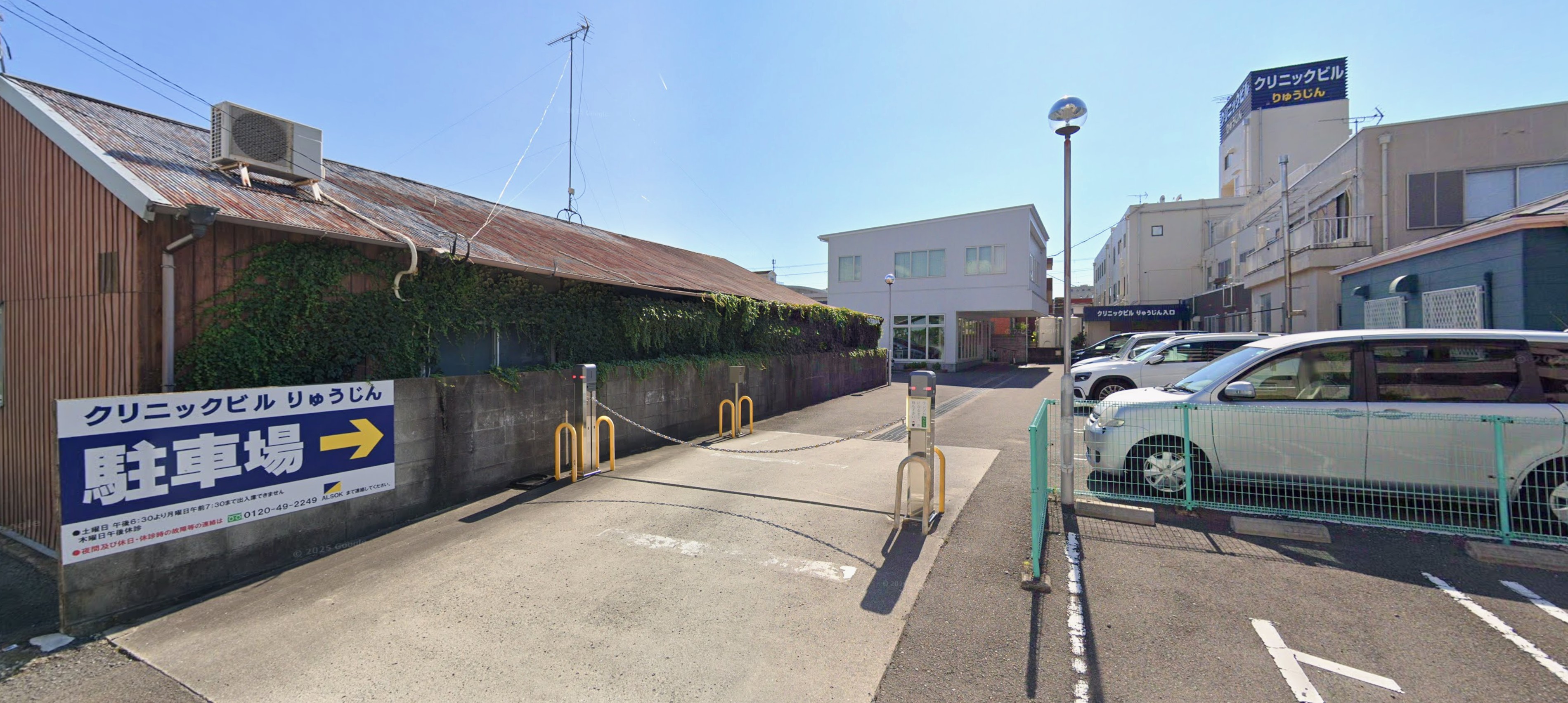クリニックビル りゅうじん 駐車場の入口。「駐車場 →」の看板が目印です。